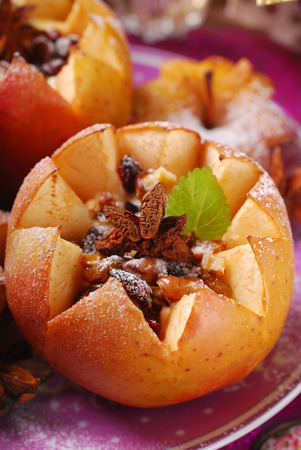 baked apples stuffed with cheese,honey,nuts,raisins and cranberries poured caramel sauce for christmas dessertの写真素材
