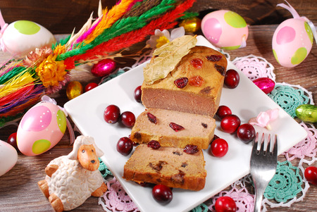 plate of homemade goose pate with cranberries for easter on wooden tableの写真素材