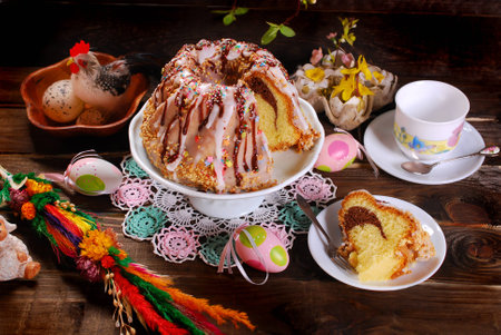easter ring cake with icing ,chocolate glaze and colorful sprinkles on wooden background