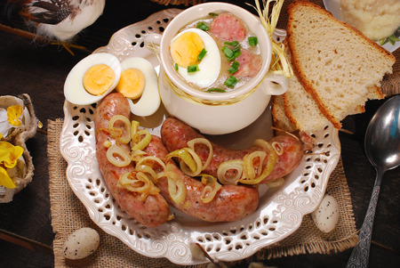 easter white borscht with eggs and roasted sausage on rural wooden backgroundの写真素材