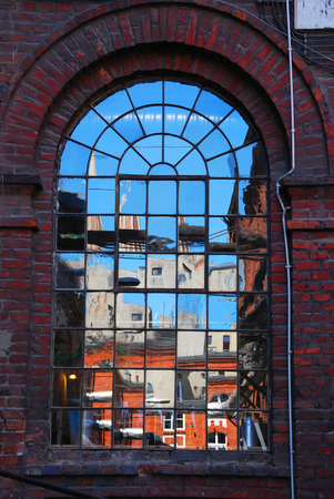 reflection of buildings in old textile factory window in Lodz,Poland
