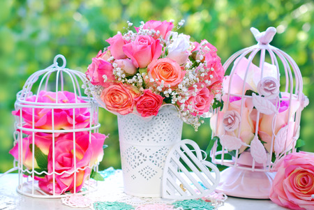 romantic style decoration with rose bouquet and metal cages in summer gardenの写真素材