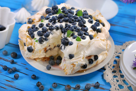 blueberry pavlova cake on blue wooden tableの写真素材