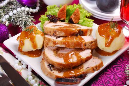 christmas dinner with loin of pork stuffed with dried figs, puree potato balls and sweet sauceの写真素材