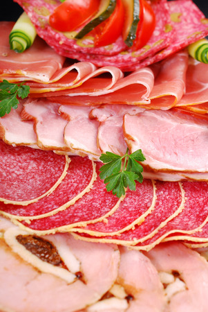 platter of sliced ham and cured meatの写真素材