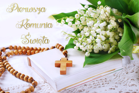 the first holy communion with wooden rosary,prayer  book and bunch of lily of the valley-polish language versionの写真素材