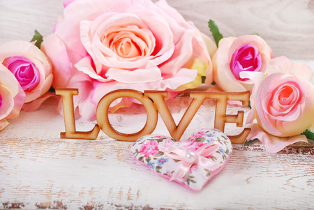 romantic background with LOVE and roses on old wooden planksの写真素材