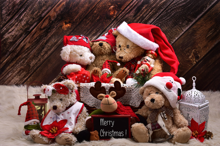 christmas teddy bear family in santa claus outfits with decorations and old toys sitting  on wooden wall  backgroundの写真素材