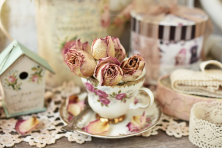 beautiful dried roses in vintage style porcelain cup  with shallow focusの写真素材
