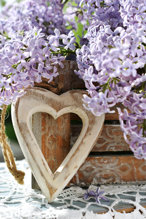 wooden heart and bunch of fresh lilac flowers still life as love conceptの写真素材