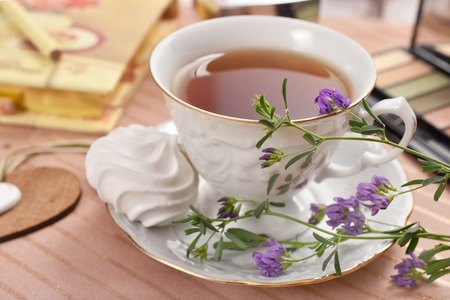 cup of tea and meringue cookie on the tableの写真素材