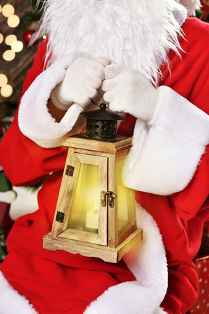 closeup of santa claus holding vintage style lantern with a lighted candleの写真素材