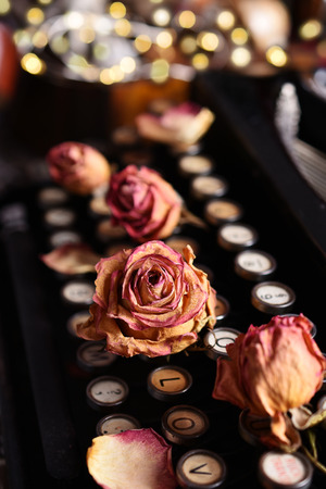 dried roses lying on the keyboard of vintage typewriterの写真素材