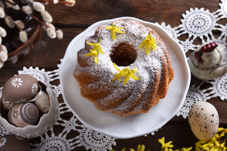 top view of easter ring cake with powdered sugar on festive table in rustic styleの写真素材