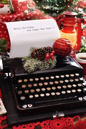 Christmas wishes typed on vintage typewriter decorated with fir, cone and ornamentの写真素材