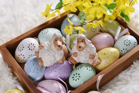 easter decoration with colorful eggs and lamb figurines in wooden boxの写真素材