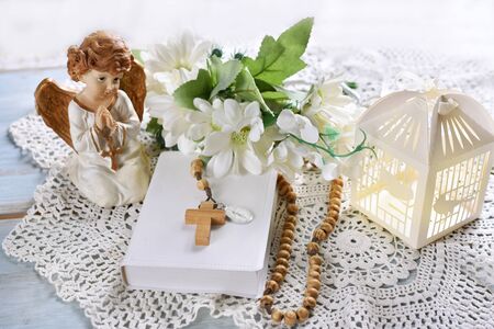 First Holy Communion still life with prayer book, rosary, angel and floral wreath