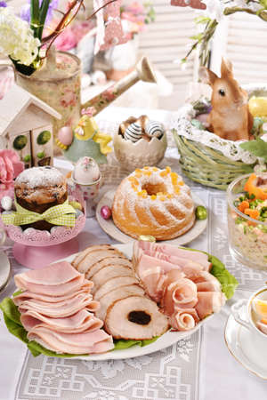 traditional Easter dishes with platter of cured meat and cakes on festive table in Polandの写真素材