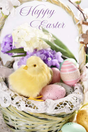 Wicker basket with a cute chicken and colorful eggs on Easter table