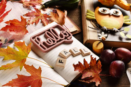Hello Fall background with opened diary notebook with colorful leaves and creative inscriptionの写真素材