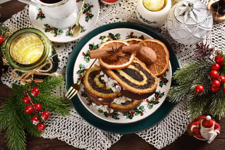 Slices of Christmas poppy seed roll cake on festive tableの写真素材