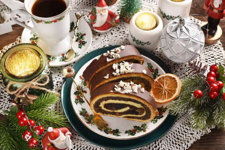 Slices of Christmas poppy seed roll cake on festive tableの写真素材