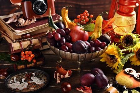 Autumn still life with seasonal fruits and decors in vintage silver bowl in rustic styleの写真素材
