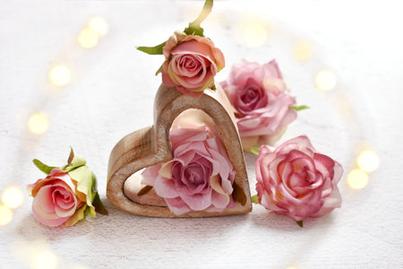 Valentines card with wooden heart and roses on white backgroundの写真素材