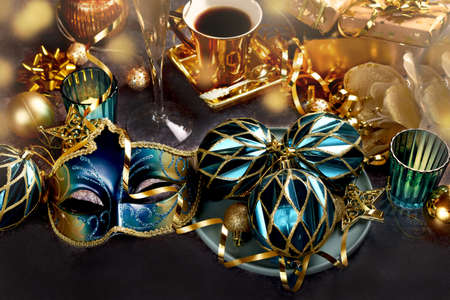 Carnival party decorations with venetian mask and ornaments in turquoise and golden colors on the tableの写真素材