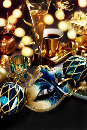 Carnival party decorations with venetian mask and ornaments in turquoise and golden colors on the tableの写真素材