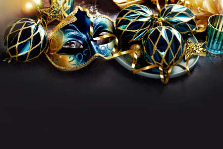 Carnival party decorations with venetian mask and ornaments in turquoise and golden colors with copy space for own textの写真素材