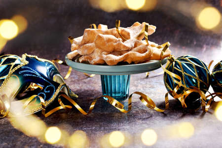 Traditional in Poland deep fried pastry faworki and carnival party decorations on dark backgroundの写真素材