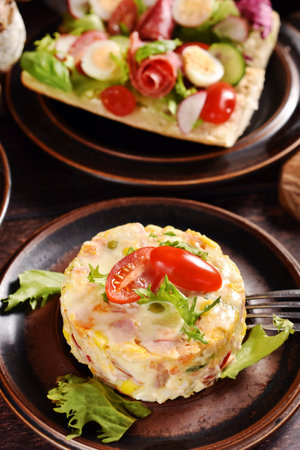 Vegetable salad in round shape and salami, quail egg and lettuce sandwich on rustic style table for Easterの写真素材