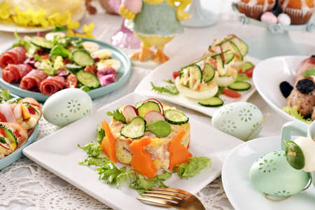 Easter table with traditional vegetable salad with mayonnaise, stuffed eggs and fresh salami saladの写真素材