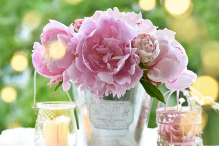 Bouquet of fresh pink peonies on the table in the garden in romantic styleの写真素材