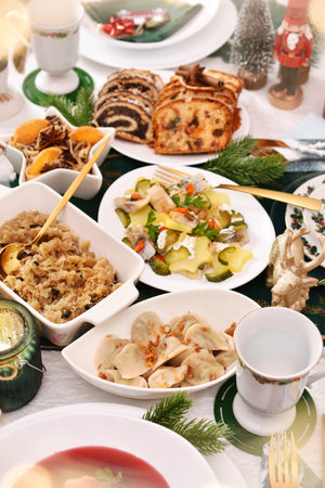 Traditional Polish Christmas Eve's dishes like mushroom ravioli, herring salad, sauerkraut, red borscht and pastriesの写真素材
