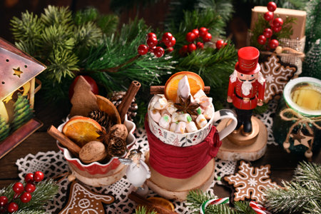 A cup of Christmas coffee or hot chocolate with marshmallows and caramel on wooden table with festive decorationsの写真素材