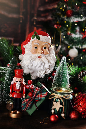 Christmas still life with Santa Claus head decor, nutcracker, candle and Christmas trees and fir branchesの写真素材