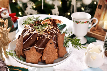 Chocolate glazed ring cake with gingerbread cookie decor for Christmas on festive tableの写真素材