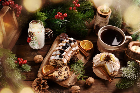 Sliced stollen cake on wooden board, meringue tart with lemon curd and coffee for Christmas on rustic style tableの写真素材