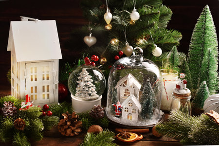 Christmas decoration with white house shaped decorsunder the glass cloche, snow ball and big house lantern on the tableの写真素材