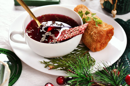 Traditional Christmas Eve red borscht and croquette filled with sauerkraut and mushrooms on festive tableの写真素材