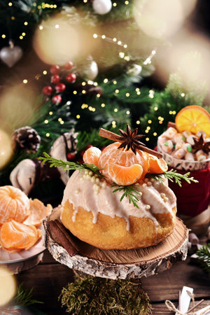 Christmas ring cake with icing and fresh mandarin decoration on the top on festive table in rustic styleの写真素材