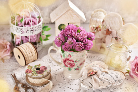 Romantic bouquet of red clover flowers in a cup on a vintage style tableの写真素材
