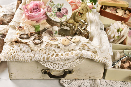 White wooden drawer with vintage style sewing supplies and laces on the table