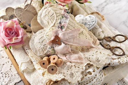 White wooden drawer with vintage sewing supplies, handmade textile heart and laces-top viewの写真素材
