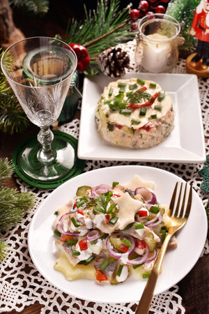 Two herring and vegetable salads for traditional Polish Christmas Eve super on rustic style tableの写真素材