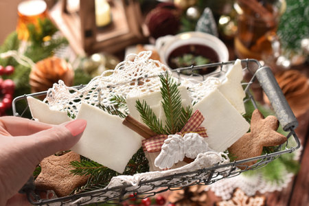 A wire basket with Christmas Eve wafer to share it with the family held above the table with traditional Polish dishesの写真素材