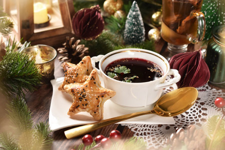 Christmas Eve red borscht with star shaped puff pastry pies stuffed with mushrooms on wooden tableの写真素材