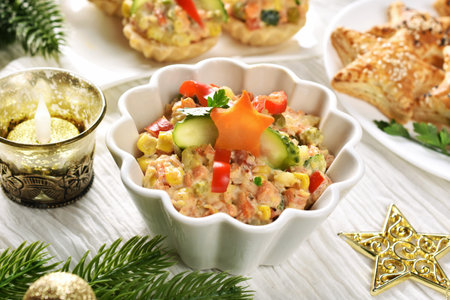 A bowl of vegetable salad with potato, carrot, green peas, corn and others with mayonnaise for Christmasの写真素材